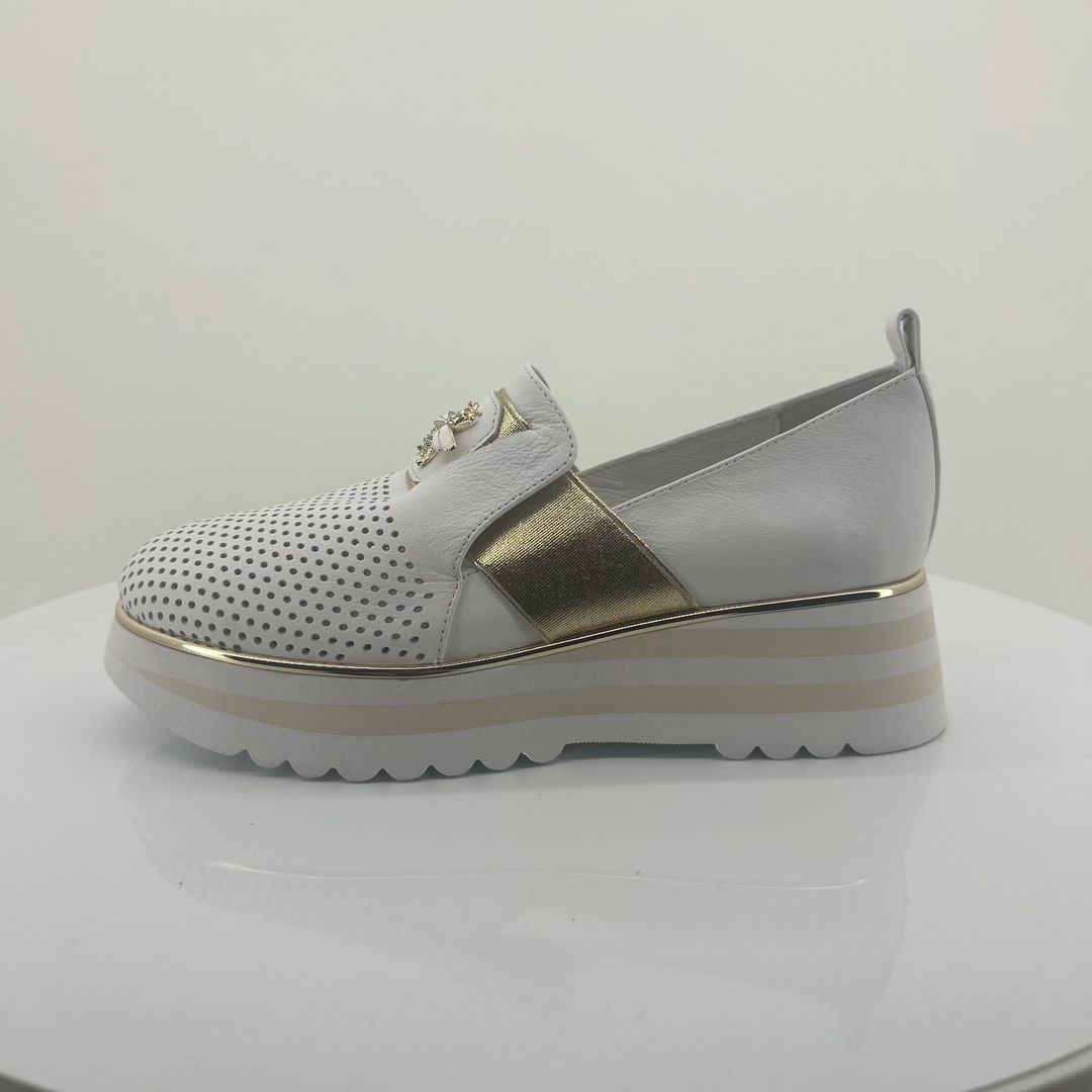 White shoe with gold accents on a white background