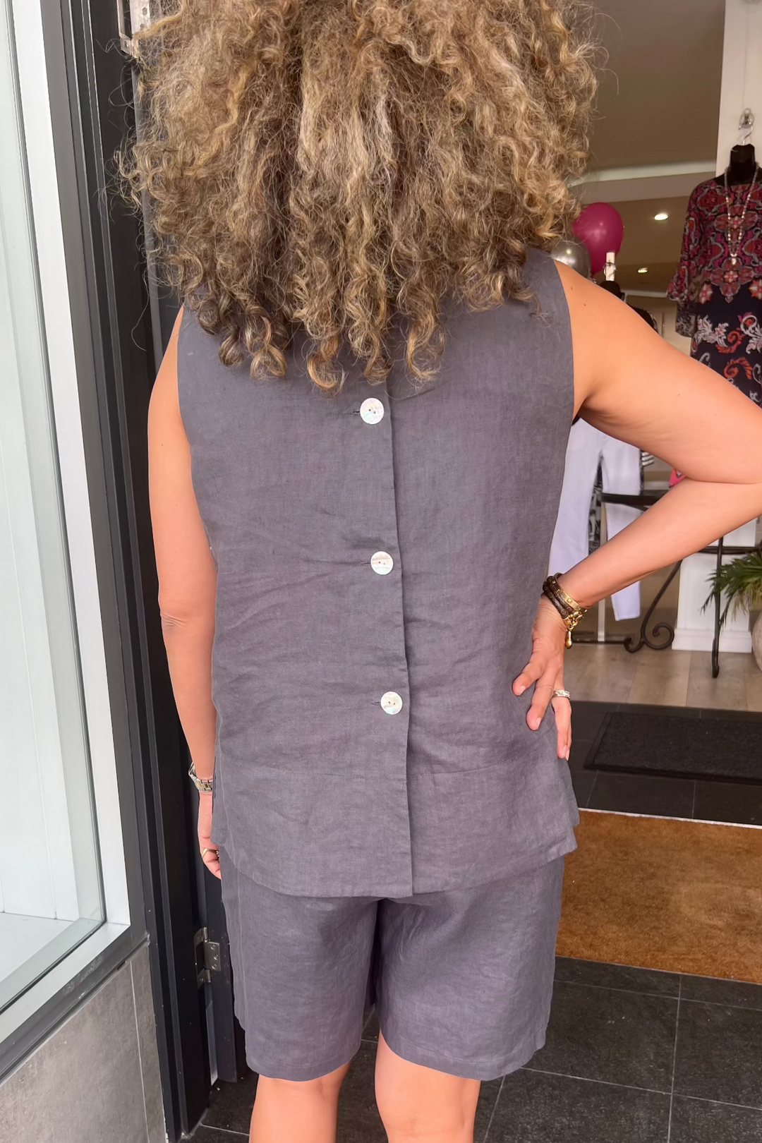 Person wearing a gray sleeveless top and shorts set in a store setting.