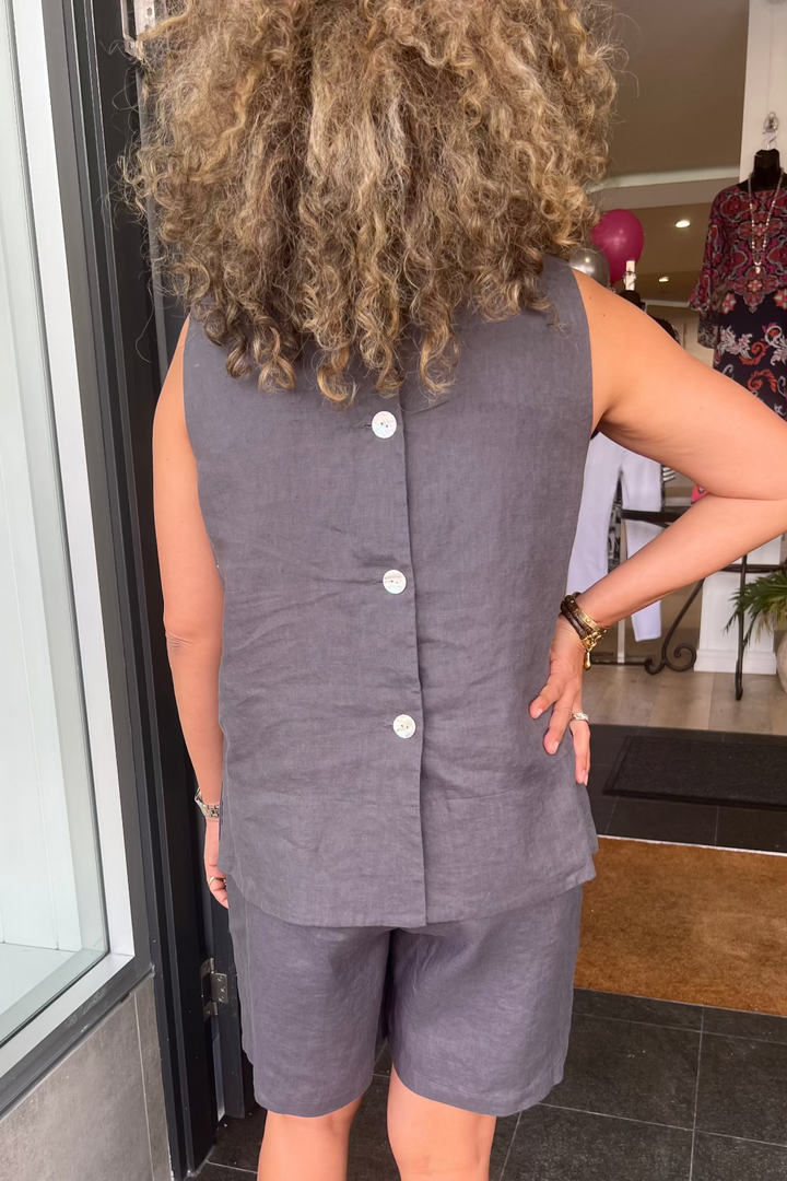 Person wearing a gray sleeveless top and shorts set in a store setting.