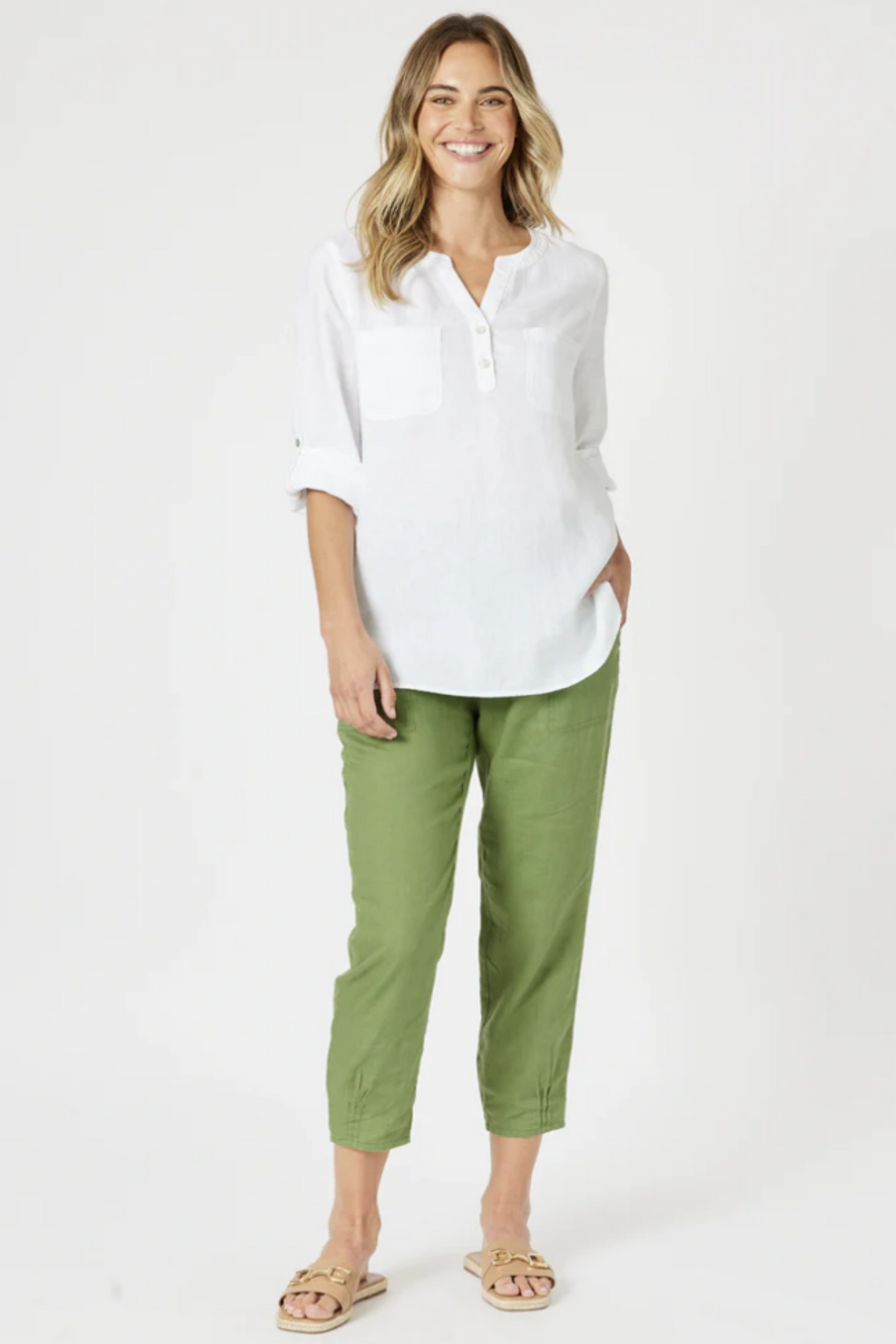 Woman wearing a white shirt and green pants on a white background