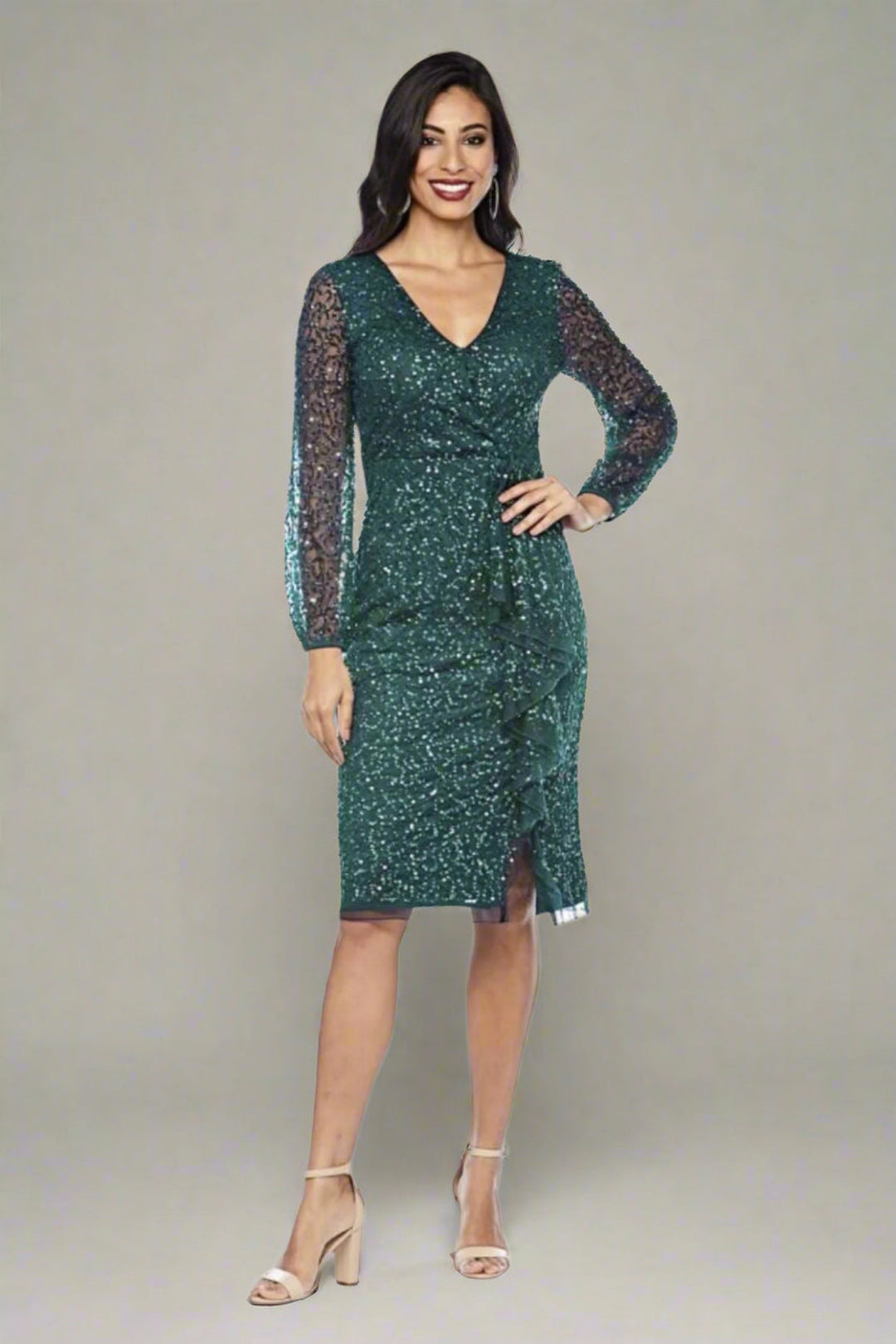 Lady Standing in Emerald Green Sequinned long sleeve dress with v-neck below knee length.. wear this dress to wedding or special events.