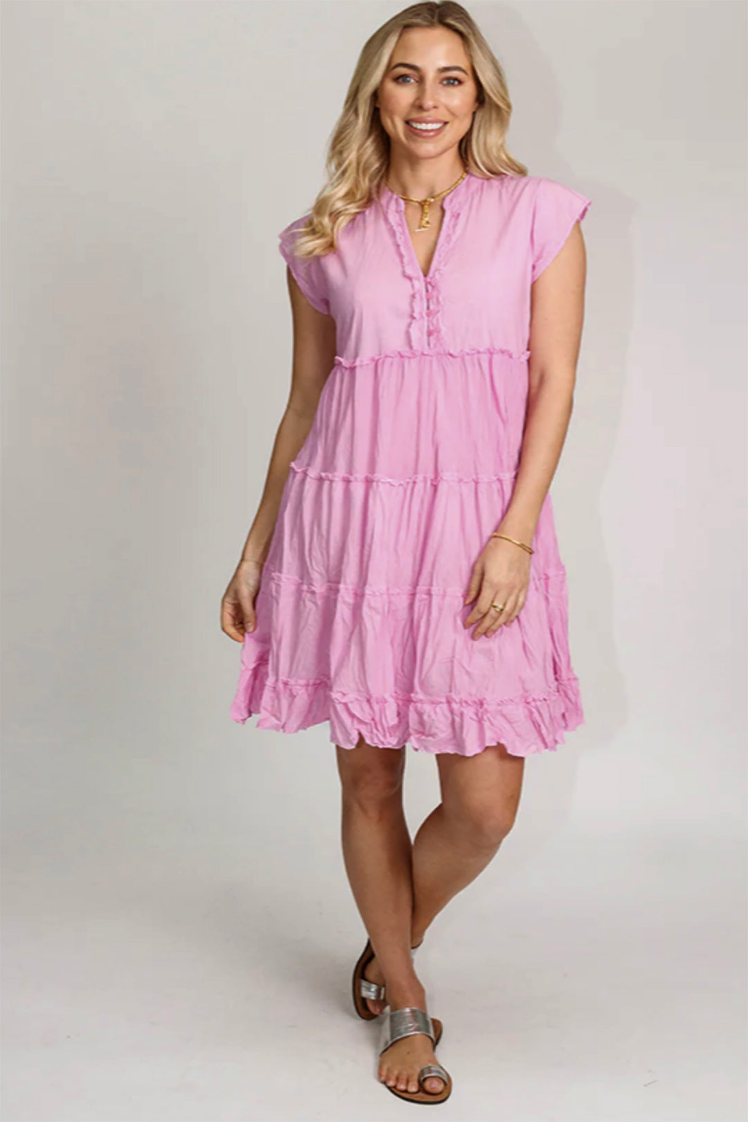 Women standing in a pink colour dress with buttons on front cap sleeves knee length, made from cotton , sold and shipped by Pizazz Boutique Nelson bay NSW Australia