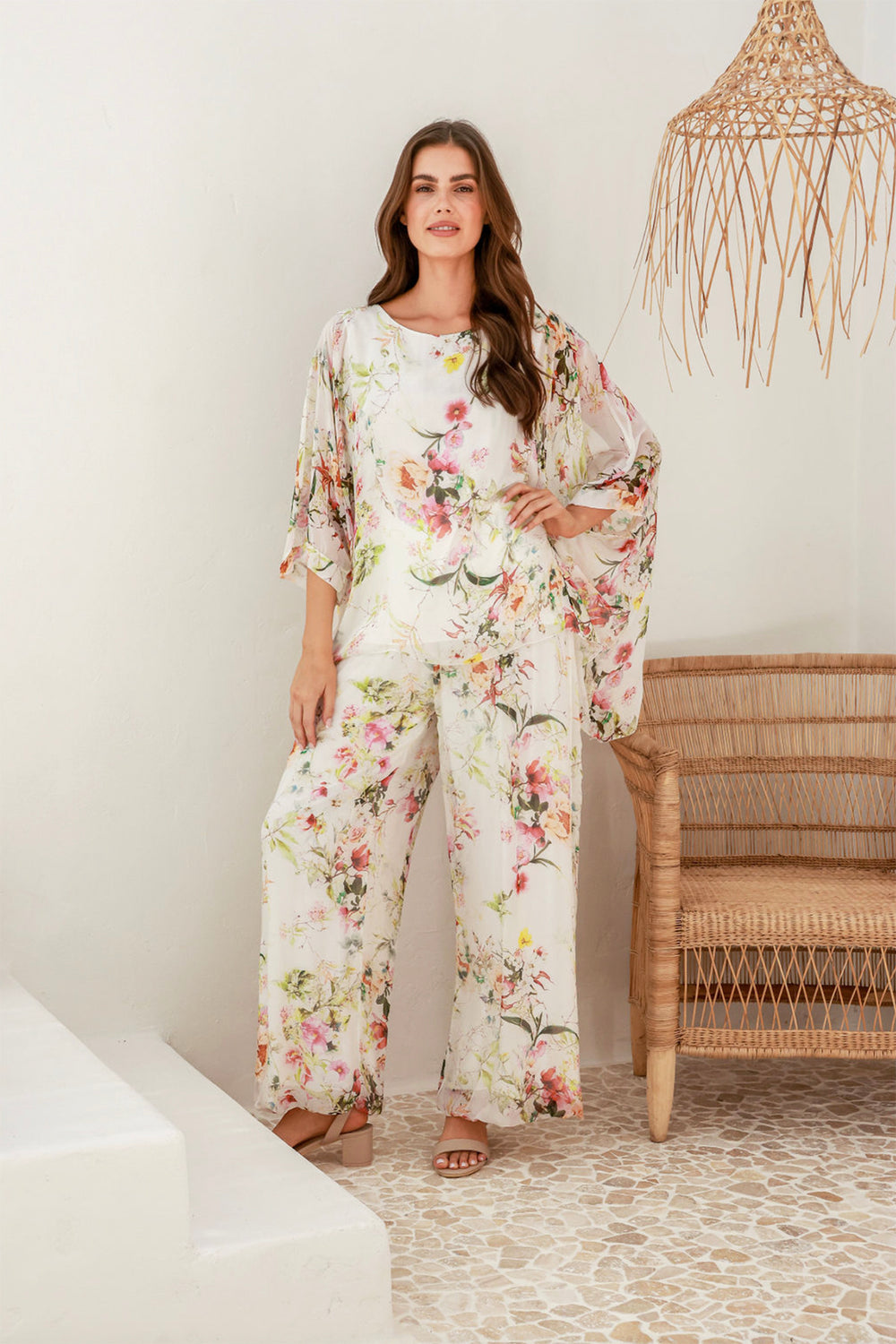 Woman wearing a pair of floral pants and a floral top by The Italian Cartel, sold and shipped from Pizazz Boutique online women's clothes shops Australia front view