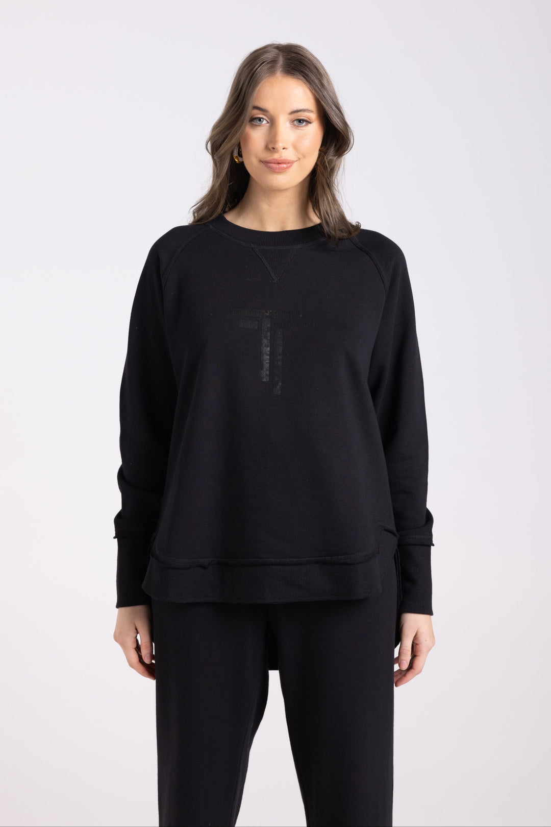 Lady wearing jumper in Black with two T's Sequinned on the front.