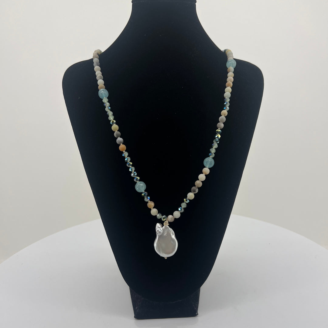 Necklace with a pendant on a black mannequin bust against a white background