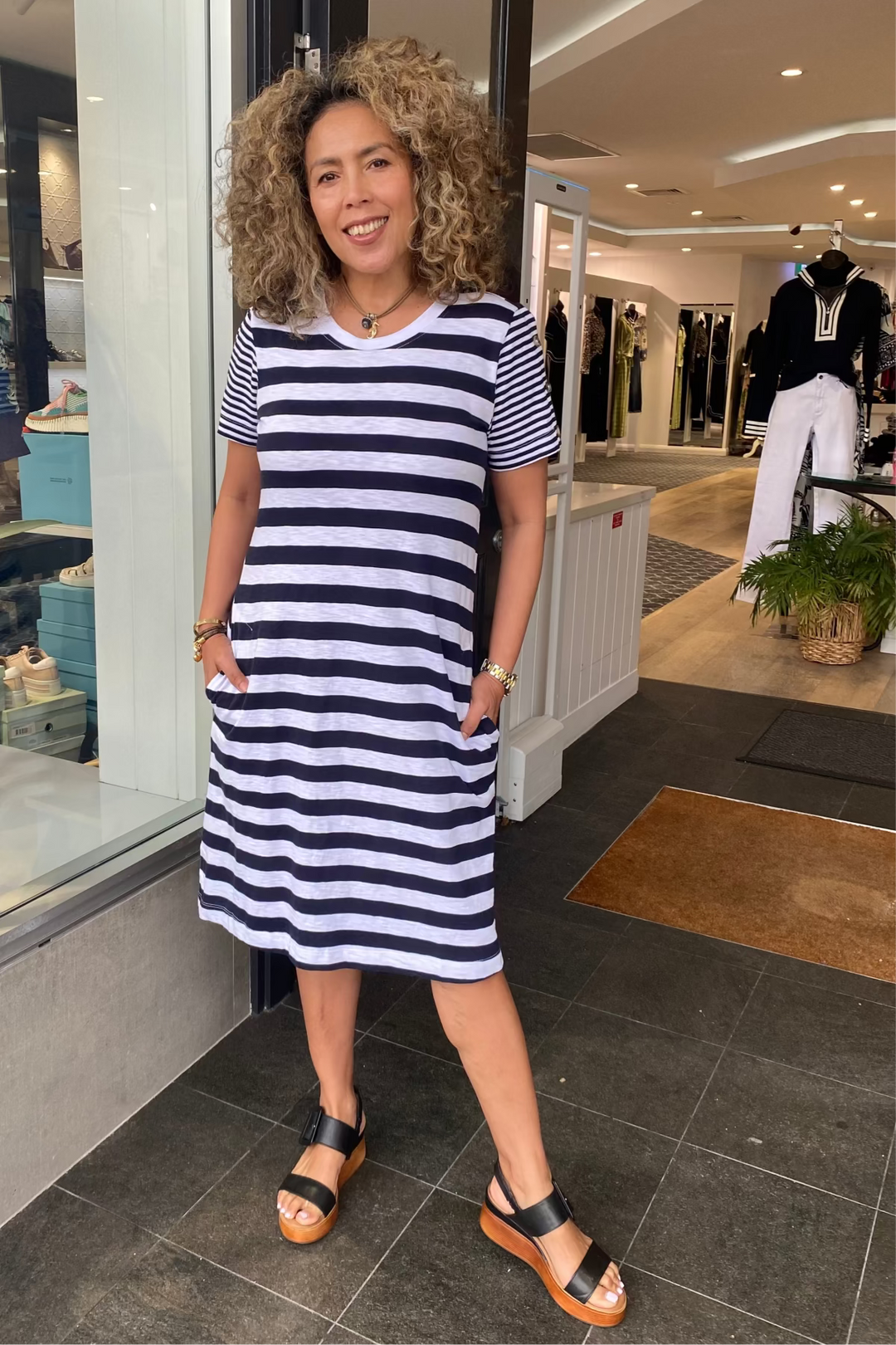 Woman in a striped dress standing in a store entrance