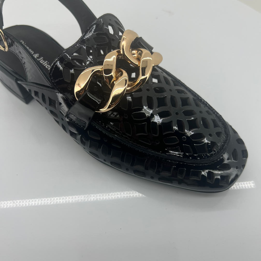 Black shoe with gold chain detail on a white background
