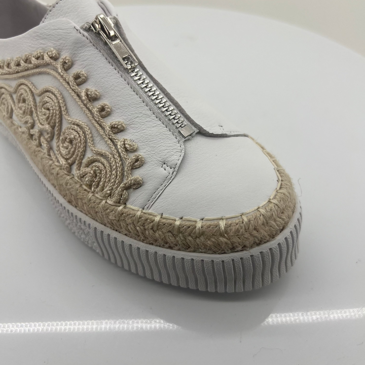 White sneaker with decorative pattern and zipper on a white background