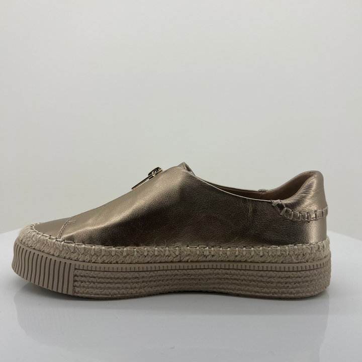 Bronze-colored slip-on shoe with textured sole on a light gray background