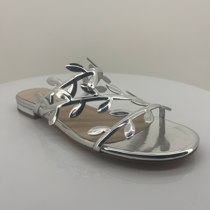 Silver sandal with leaf designs on a white background
