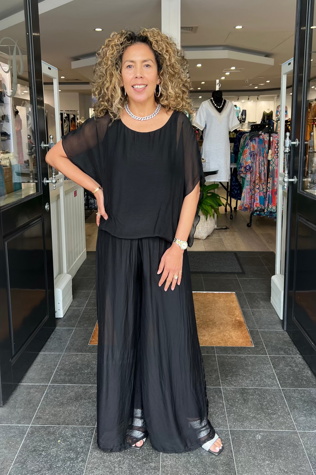 Woman in a black outfit standing in a store entrance