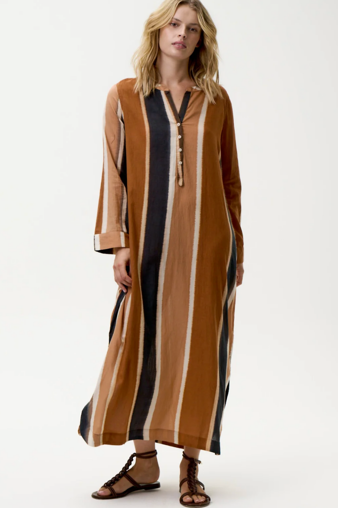 Woman wearing a long, striped dress with a white background