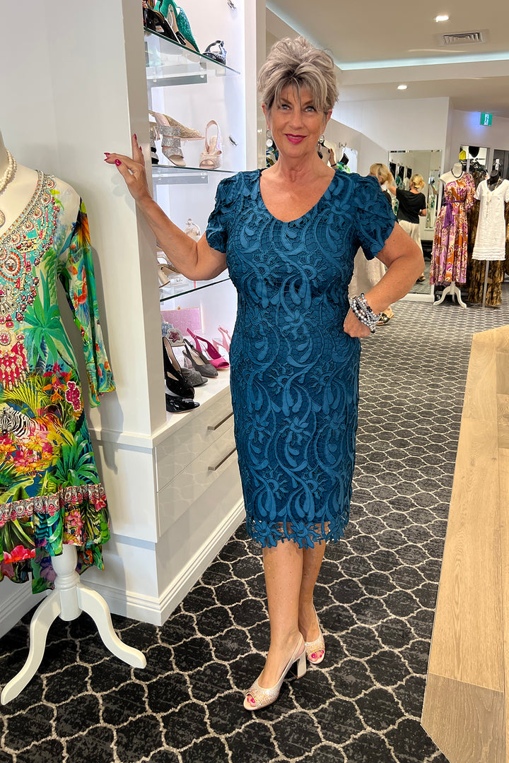 Woman wearing a teal lace dress by Frank Lyman, sold and shipped from Pizazz Boutique