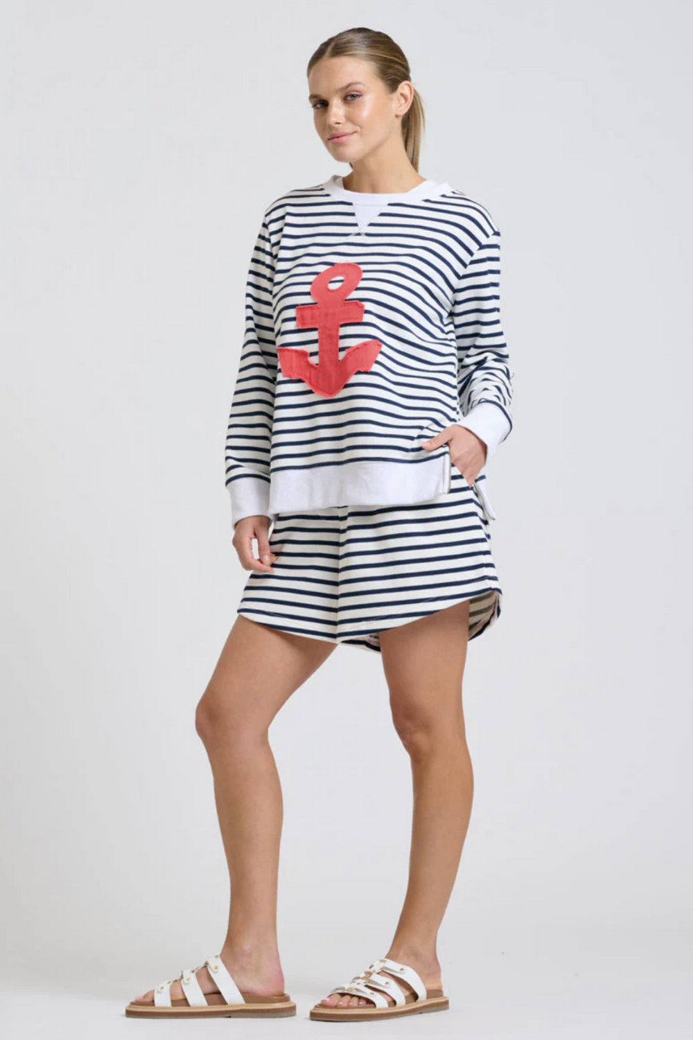Woman wearing a striped outfit with an anchor design on a white background