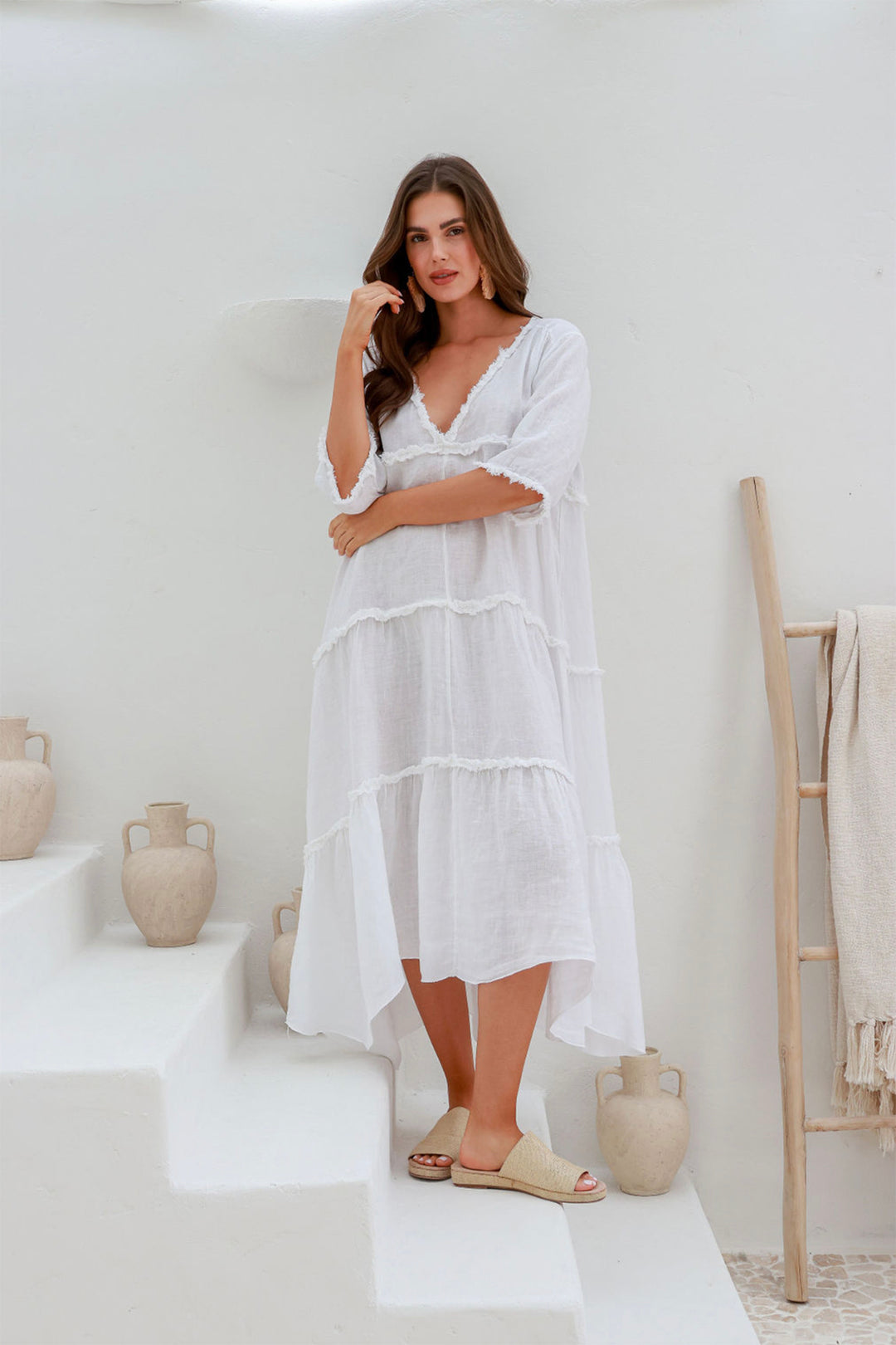 Woman wearing a white 100% linen dress with a V-neck by The Italian Cartel, sold and shipped from Pizazz Boutique online women's clothes shops Australia front view