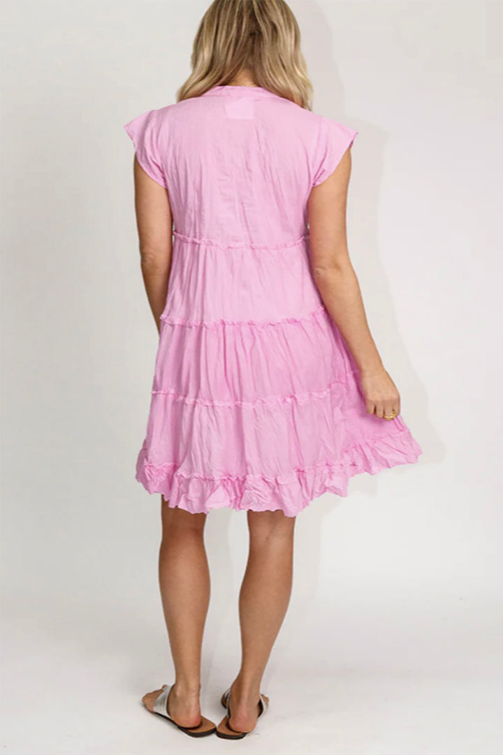 Back photo of a Women standing in a pink colour dress with buttons on front cap sleeves knee length, made from cotton , sold and shipped by Pizazz Boutique Nelson bay NSW Australia