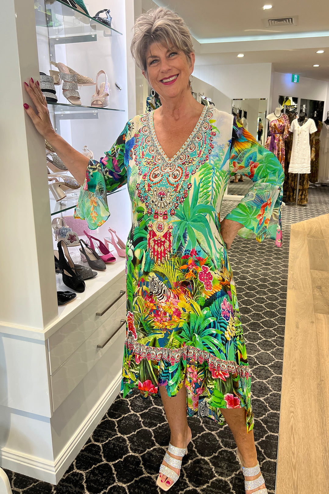 ladies Standing in a bright jewelled dress called the paradise resort dress by fashion Spectrum. Sold & Shipped By Pizazz Boutique Nelson Bay.    