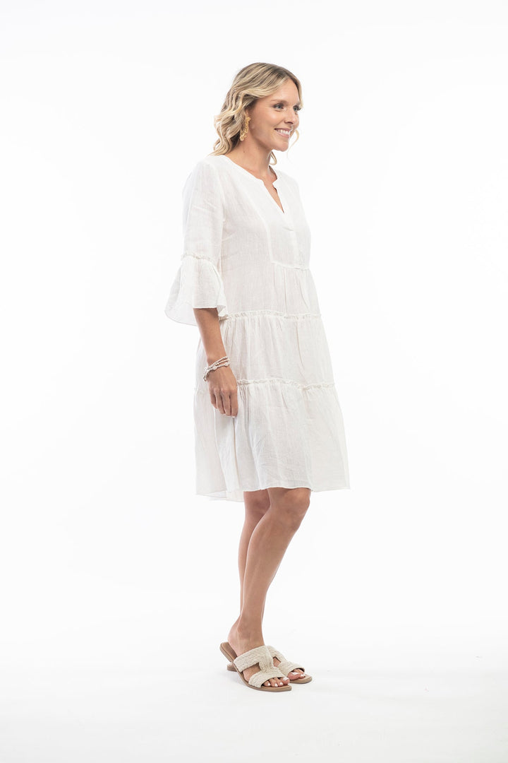 Woman wearing a cream linen dress and sandals by Escape By OQ, Sold and shipped from pizazz Nelson Bay, women's dresses online Australia side view