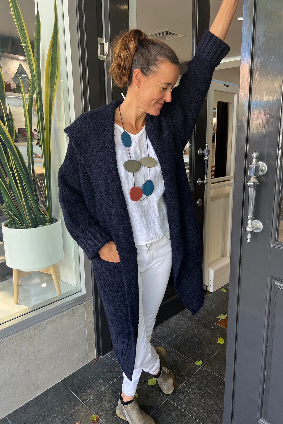 Woman wearing a navy betty bounce cardi by Italian Star, sold and shipped from Pizazz Boutique Nelson Bay women's dresses online Australia